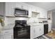 White kitchen cabinets, black appliances, and white subway tile backsplash at 817 Wayne St., North Myrtle Beach, SC 29582