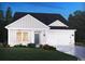 Inviting home exterior at twilight, featuring white siding, a two-car garage, and landscaping at 1215 Arizona Dr., Longs, SC 29568