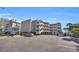 Exterior view of a beach condo complex, featuring parking and ocean views at 2405 S Ocean Blvd. # 306, North Myrtle Beach, SC 29582