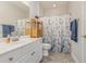 Charming bathroom with floral shower curtain, white vanity, and tile flooring at 2740 Bayboro St., Loris, SC 29569