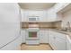 Kitchen boasts white cabinets, microwave, and electric range at 2740 Bayboro St., Loris, SC 29569