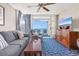 Ocean view living room with comfy seating, balcony access, and a large TV at 5200 N Ocean Blvd. # 1033, Myrtle Beach, SC 29577