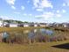 Aerial view of houses and pond, showcasing a desirable community setting at 1143 Sennema Circle, Myrtle Beach, SC 29588