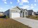 House exterior showcasing a green facade, white garage door, and well-maintained lawn at 1143 Sennema Circle, Myrtle Beach, SC 29588