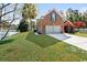 Brick home with a two-car garage, situated on a grassy lot next to a pond at 305 Duel Ct., Myrtle Beach, SC 29588