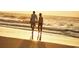 Couple walks hand-in-hand along the shore at sunset on a beautiful beach at 731 Isle Verde Dr, Myrtle Beach, SC 29579