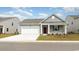 Gray house with white garage door and red front door, landscaped yard at 189 Ashworth Dr., Tabor City, NC 28463