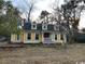 Front view of a classic yellow two-story house with white trim and a covered porch at 2708 Main St., Loris, SC 29569