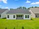Rear view of house, showcasing covered patio and lawn at 1073 Nw Rosefield Way, Calabash, NC 28467