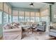 Relaxing sunroom with light-filled windows, comfortable seating, and a ceiling fan at 116 Saint James St., Georgetown, SC 29440