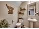Stylish bathroom with pedestal sink, floating shelves, and toilet at 5433 Merrywind Ct., Myrtle Beach, SC 29579