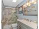 Bathroom with gray vanity, tiled shower, and framed mirror at 6001-Mh81 S Kings Hwy., Myrtle Beach, SC 29575