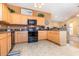 Kitchen with wood cabinets, black appliances, and breakfast bar at 1133 Spalding Ct., Surfside Beach, SC 29575