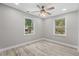 Bright bedroom with two windows and ceiling fan at 137 Whipporwill Dr, Pawleys Island, SC 29585