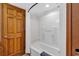 Bathroom with tub shower and wood door at 4800 S Ocean Blvd. # 412, North Myrtle Beach, SC 29582
