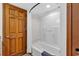 Bathroom with tub shower and wood door at 4800 S Ocean Blvd. # 412, North Myrtle Beach, SC 29582