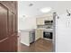 View of the kitchen from the entryway showing stainless steel appliances and light cabinets at 1100 Possum Trot Rd. # E235, North Myrtle Beach, SC 29582