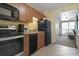 Kitchen with black appliances and wood cabinetry, view into adjacent room at 2100 North Ocean Blvd. # 923, North Myrtle Beach, SC 29582