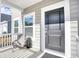 Close-up of the front porch featuring a dark front door and white siding at 268 Empyrean Circle, Myrtle Beach, SC 29588