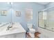 Blue bathroom with white dual vanity, toilet, and shower with glass door at 411A Ocean Blvd. S, Surfside Beach, SC 29575