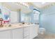 Light blue bathroom featuring double vanity, white cabinets, and decorative border at 411A Ocean Blvd. S, Surfside Beach, SC 29575