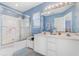 Bathroom with double vanity, shower/tub combo, and light blue walls at 411A Ocean Blvd. S, Surfside Beach, SC 29575
