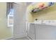 Laundry room with white washer and dryer, storage shelf, and door at 411A Ocean Blvd. S, Surfside Beach, SC 29575