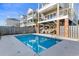 Inviting pool area with lounge chairs and surrounding beach homes at 411A Ocean Blvd. S, Surfside Beach, SC 29575