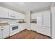 Modern kitchen featuring white cabinets, stainless steel appliances, and wood flooring at 58 Pool Pl. # 73, Georgetown, SC 29440