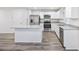 Open concept kitchen with island, stainless steel appliances, and light gray flooring at 608 Montenegro Way # E, Myrtle Beach, SC 29579