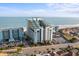 Aerial view of beachfront high-rise hotel, parking lot, and road at 6804 N Ocean Blvd. # 1215, Myrtle Beach, SC 29572