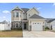 Two-story house with a gray roof, stone accents, and a two-car garage at 724 Hobonny Loop, Longs, SC 29568