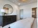 Relaxing bedroom with a dark wood dresser, a large circular mirror, and plush carpet at 998 Laconic Dr., Myrtle Beach, SC 29588