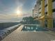 Resort-style pool with lounge chairs and ocean view at sunset at 2301 S Ocean Blvd. # 1002, North Myrtle Beach, SC 29582