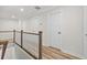 Upstairs hallway with wooden flooring and white railing overlooking staircase at 308 Golan Circle # C, Myrtle Beach, SC 29579