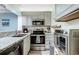 Compact kitchen featuring white cabinets, stainless steel appliances, and speckled countertops at 415 Ocean Creek Dr. # 2373, Myrtle Beach, SC 29572