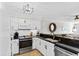 Modern kitchen featuring white cabinets, stainless steel appliances, and dark granite countertops at 4445 Kingsport Rd. # 303, Little River, SC 29566