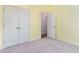Empty bedroom with pale yellow walls, closet doors, and a partially open door to another room at 509 Covewood Ct., Longs, SC 29568