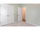 Empty bedroom with sage green walls, double closet doors, and a partially open door leading to another room at 509 Covewood Ct., Longs, SC 29568