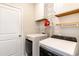 Laundry room with Whirlpool washer and dryer and built-in shelving at 509 Covewood Ct., Longs, SC 29568