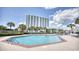 Community pool with lounge chairs and palm trees at 9820 Queensway Blvd. # 903, Myrtle Beach, SC 29572