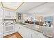 White kitchen with granite counters and view into dining area at 9820 Queensway Blvd. # 903, Myrtle Beach, SC 29572