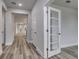 Hallway with wood-look flooring, white doors, and a view into another room at 1310 Crested Iris Way, North Myrtle Beach, SC 29582