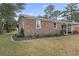 Side view of a brick ranch house showcasing the landscaping and exterior details at 1673 Middleton St., Georgetown, SC 29440