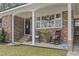 Covered front porch with rocking chairs, brick exterior, and front door at 1673 Middleton St., Georgetown, SC 29440