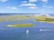 Stunning aerial view of the coastline with sailboats and lush green marshes at 3413 Cove Side Ct., North Myrtle Beach, SC 29582