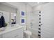 Clean, modern bathroom with bathtub, white vanity, and striped shower curtain at 3413 Cove Side Ct., North Myrtle Beach, SC 29582