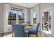 Charming dining area with blue chairs, a round table, and large windows overlooking a patio at 3413 Cove Side Ct., North Myrtle Beach, SC 29582