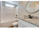 Bathroom featuring a shower-tub combo, white vanity, granite countertop, and a round mirror at 3421 B And S Rd., Loris, SC 29569