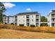 Rear exterior of the condo building with balconies and a grassy area at 476 River Oaks Dr. # 64E, Myrtle Beach, SC 29579